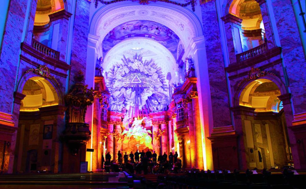 Karlskirche Wien innen mit viel Ambientebeleuchtung in Orange und blau